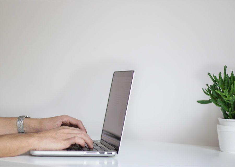 Hands typing on a laptop