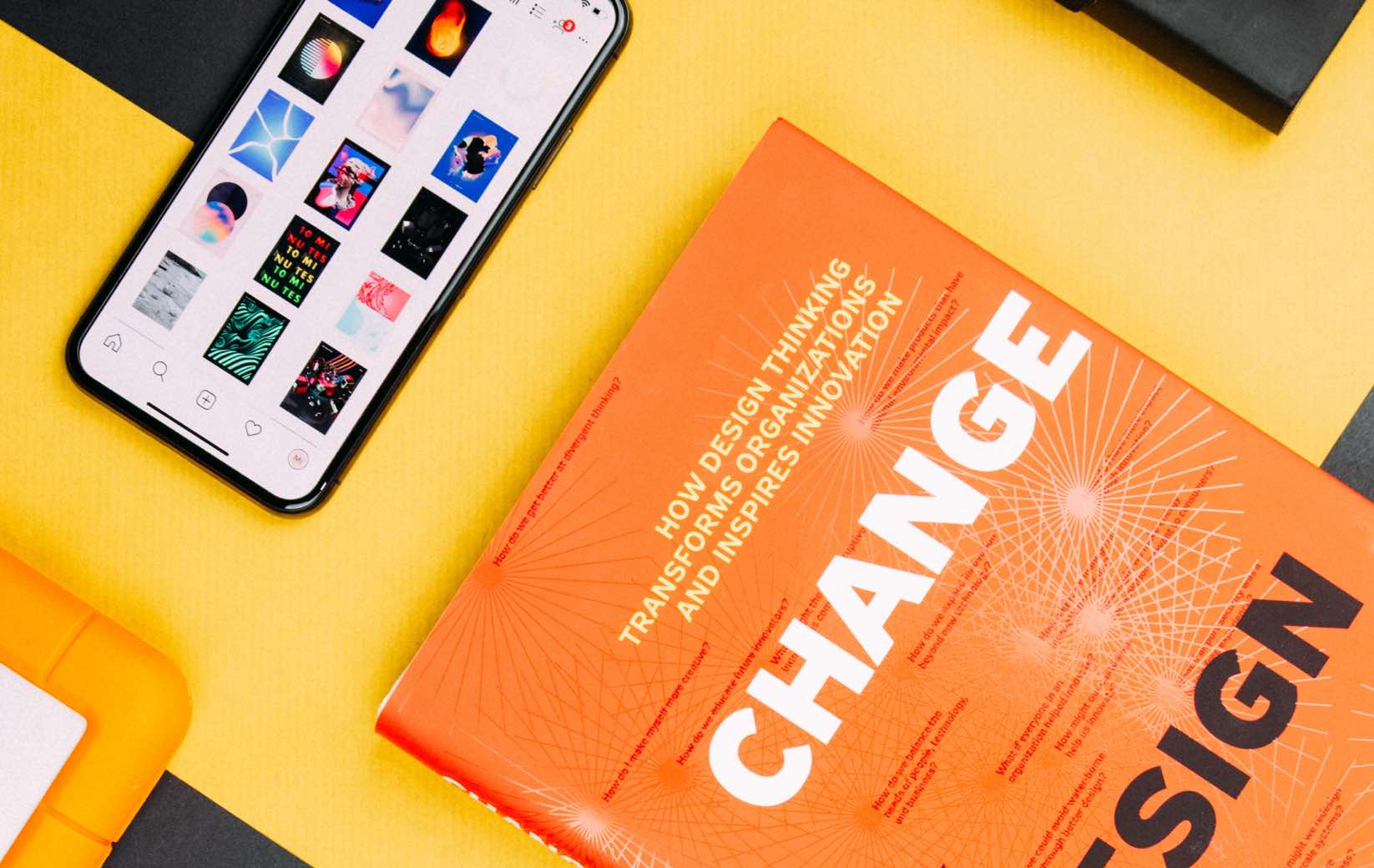 A vibrant book titled "Change" next to a smartphone displaying design images.