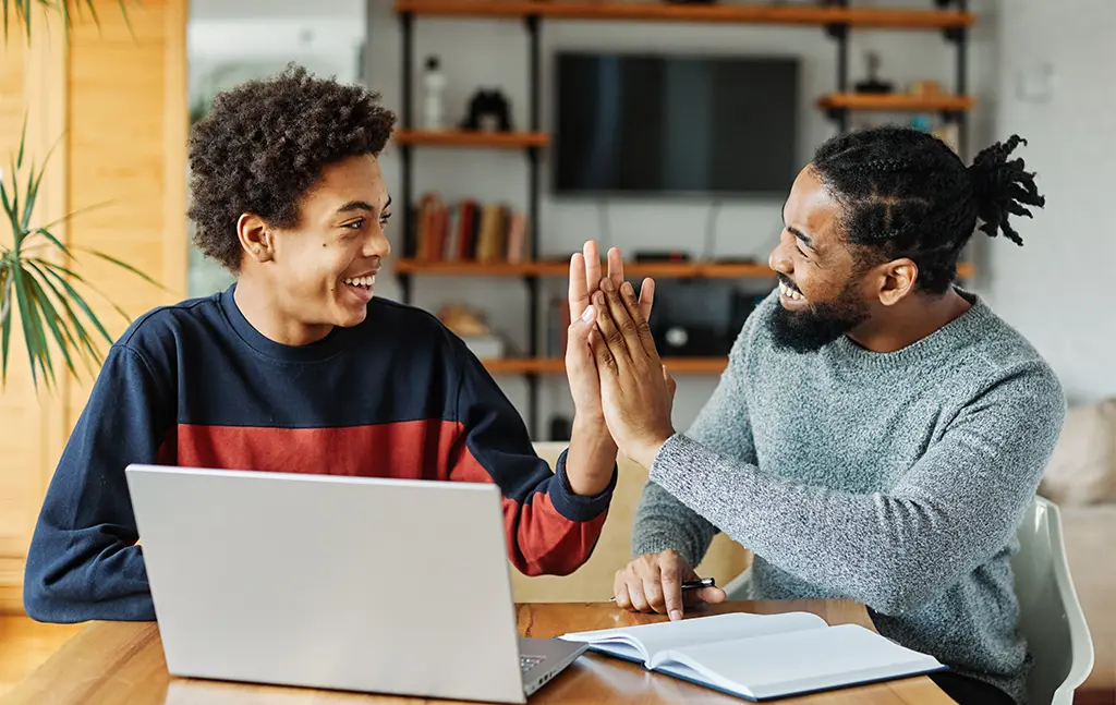 Tutor and student sharing a joyful moment during a learning session.