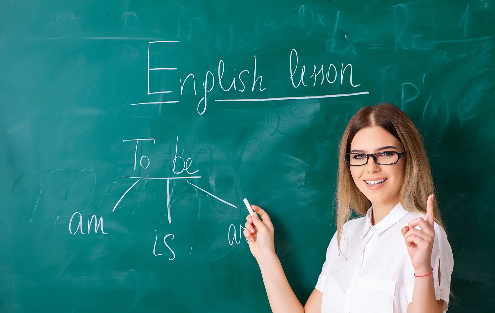 Tutor teaching English grammar on a chalkboard