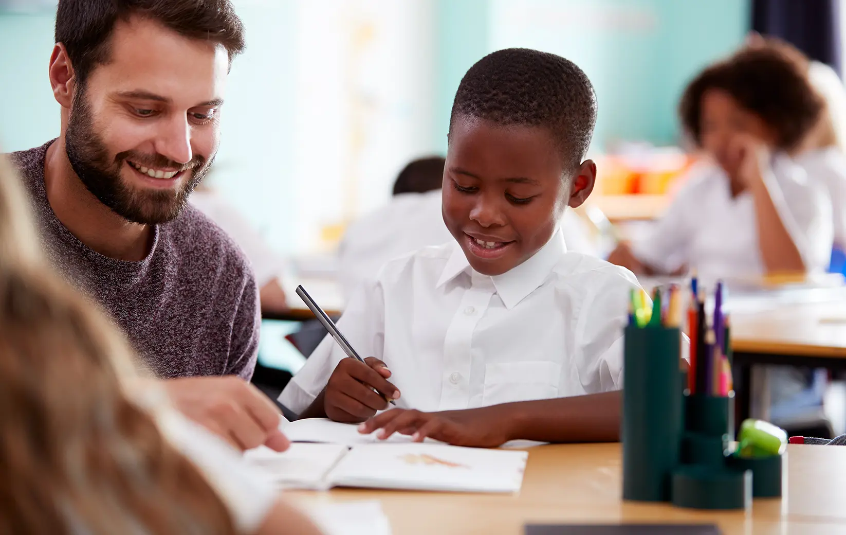Tutor and student engaged in a learning activity at a classroom desk