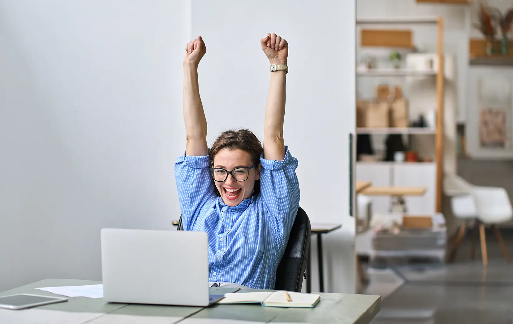 Tutor celebrating a success while working on a laptop